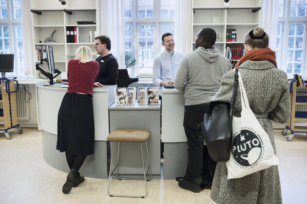 Studenter köar tlil lånedisken på samhällsvetenskapliga biblioteket